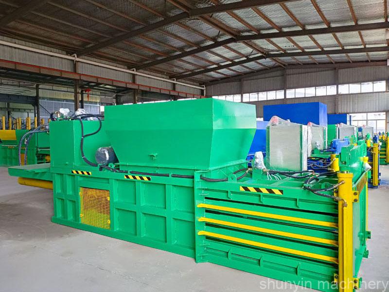 Various horizontal baler machine types displayed in warehouse