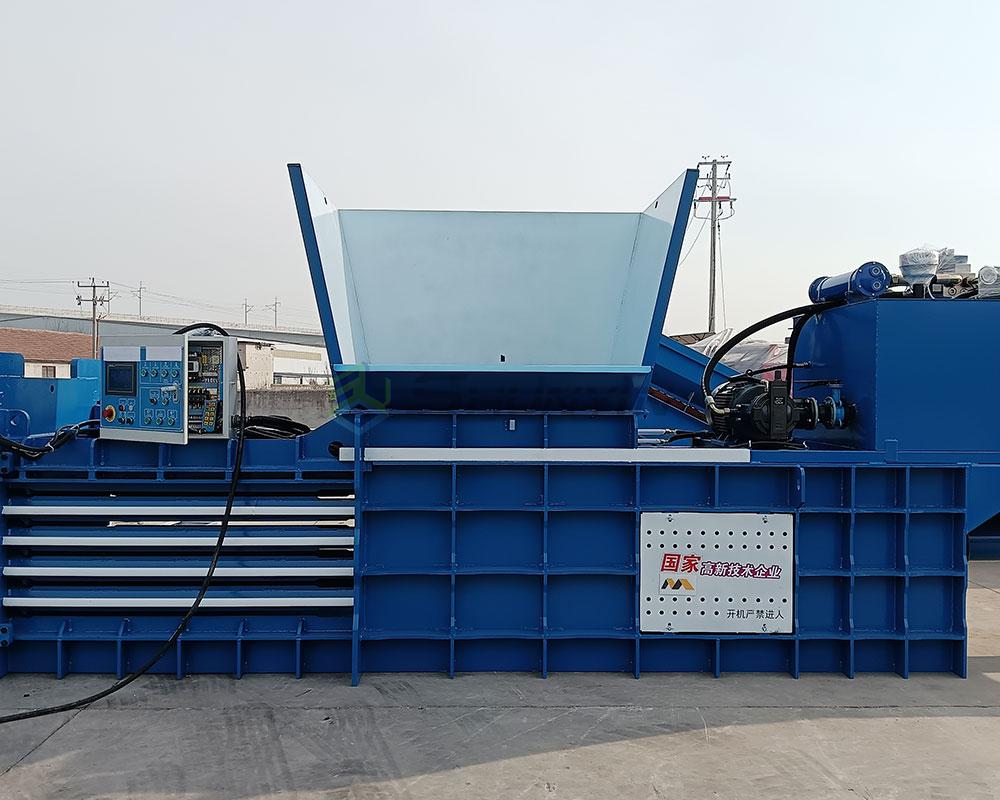 Horizontal baler processing cardboard bundles